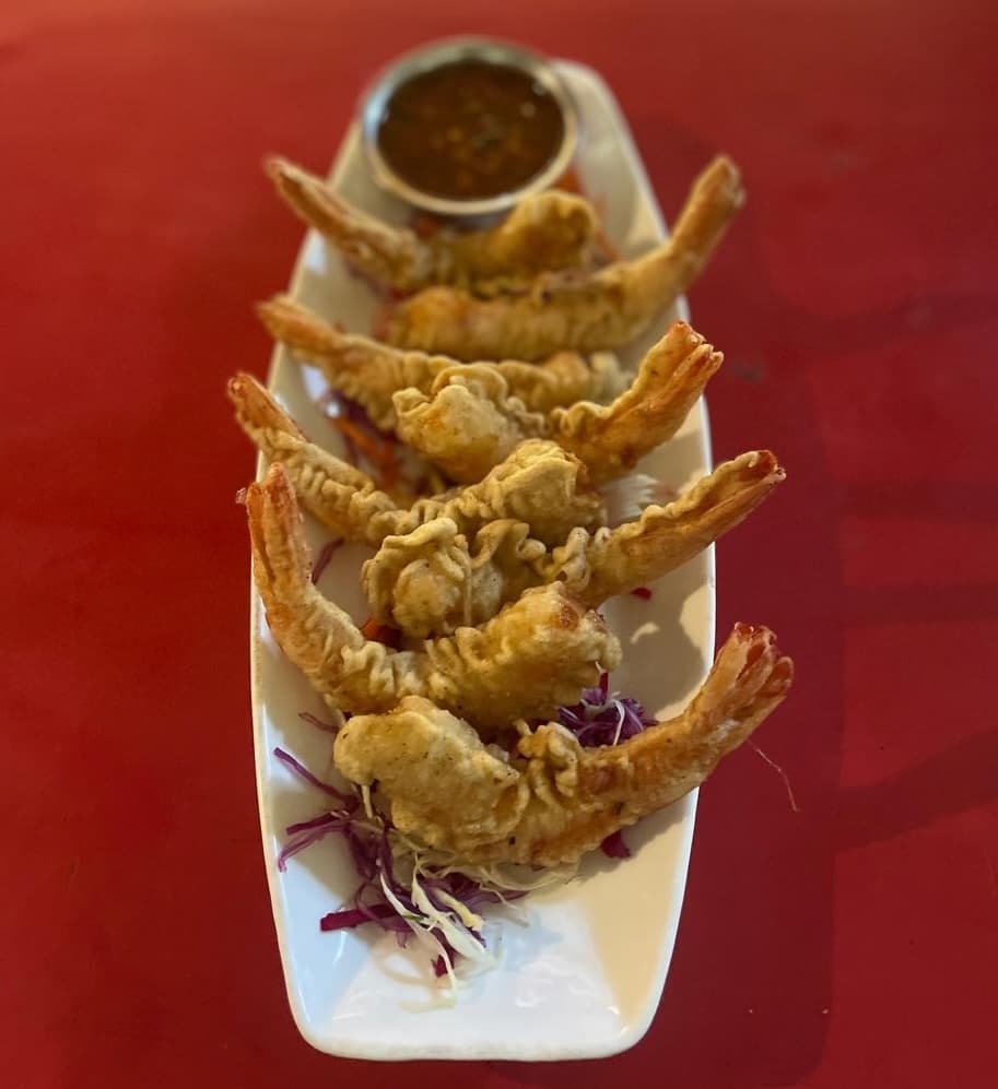 Tempura prawns with dipping sauce on a plate at German Bakery, Anjuna